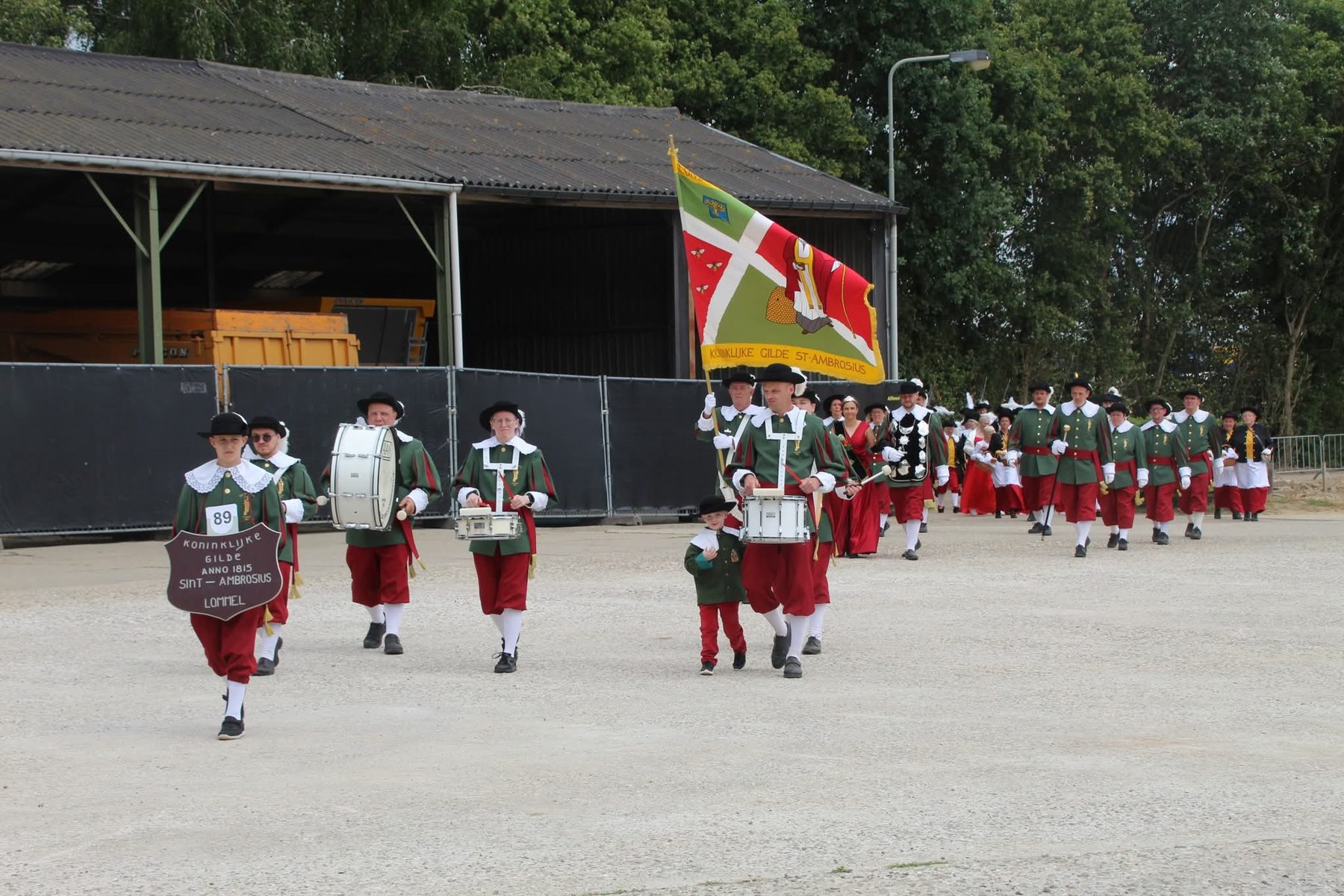 De drumband en het vaandel van de gilde in optocht